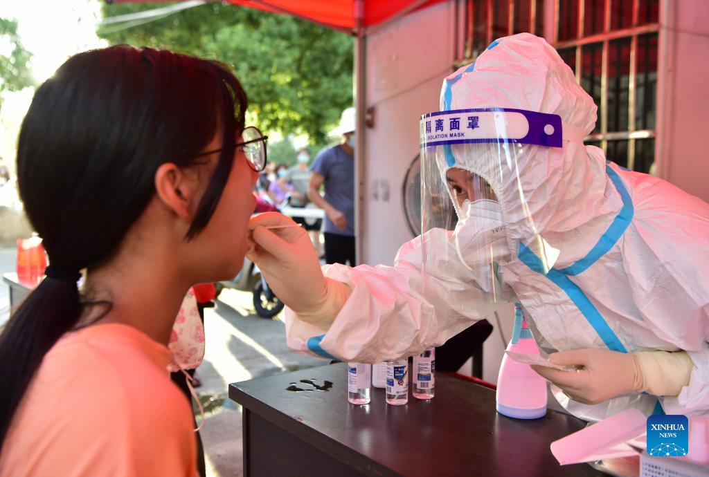 A health worker collects swab sample from a resident for COVID-19 test in Xianyou county